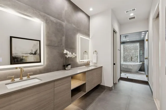a en suite bathroom with a double vanity sink and a large mirror