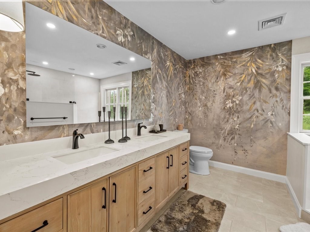 10 Beech Street Millis, MA 02054 - Photo 19 of 40 a bathroom with double vanity sink a toilet a mirror and shower