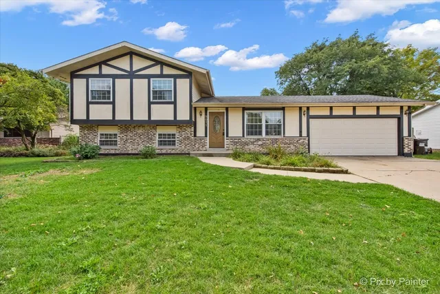 a front view of a house with yard and green space