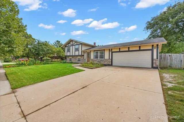 a front view of a house with a garden and yard