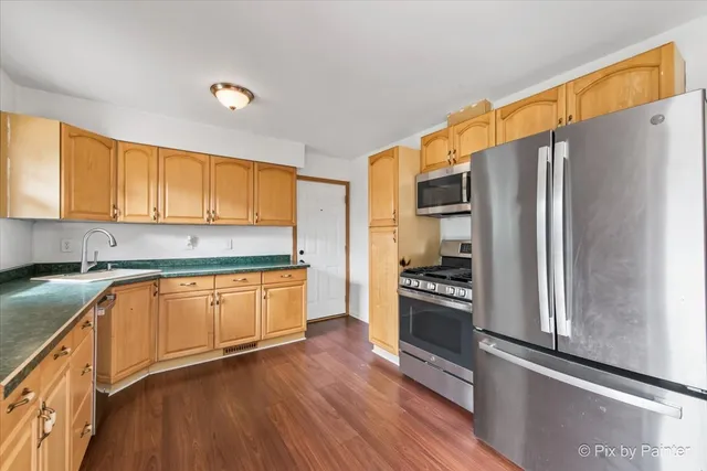 a kitchen with granite countertop stainless steel appliances and wooden cabinets