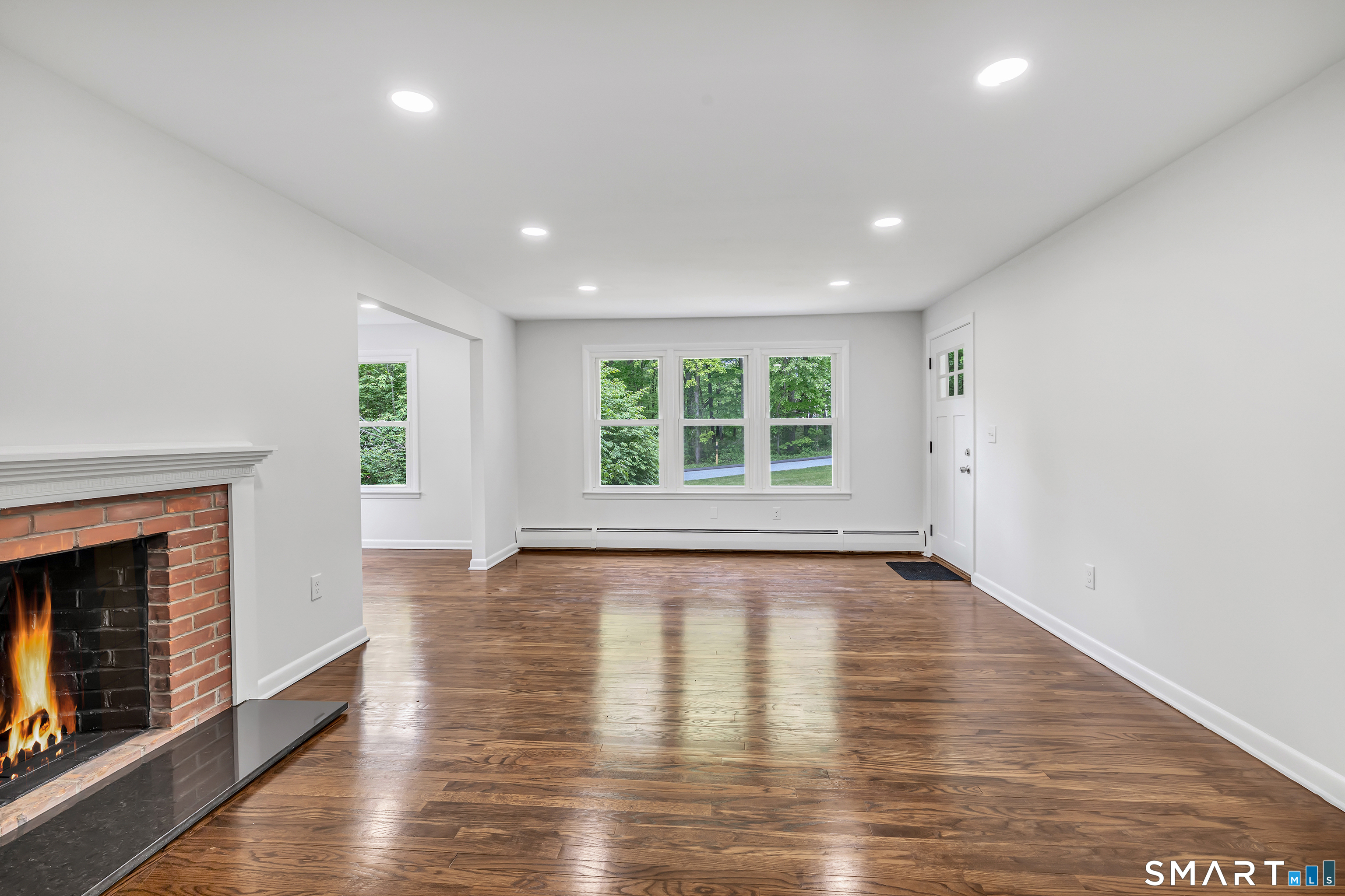 7 Longview Road Newtown, CT 06482 - Photo 5 of 40 an empty room with wooden floor and fireplace