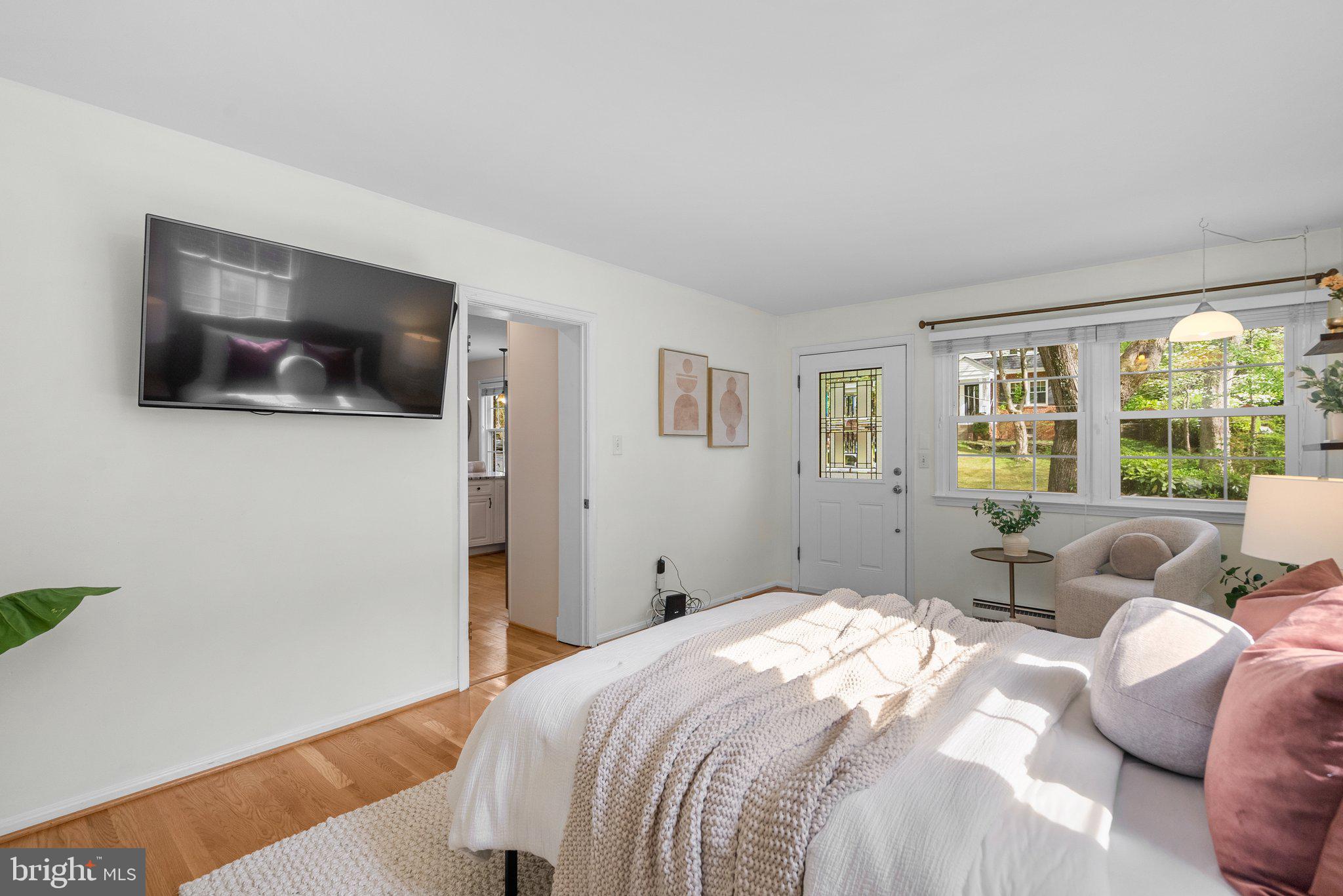 10406 Brookmoor Drive Silver Spring, MD 20901 - Photo 15 of 45 a bedroom with a large bed a flat screen tv and a window