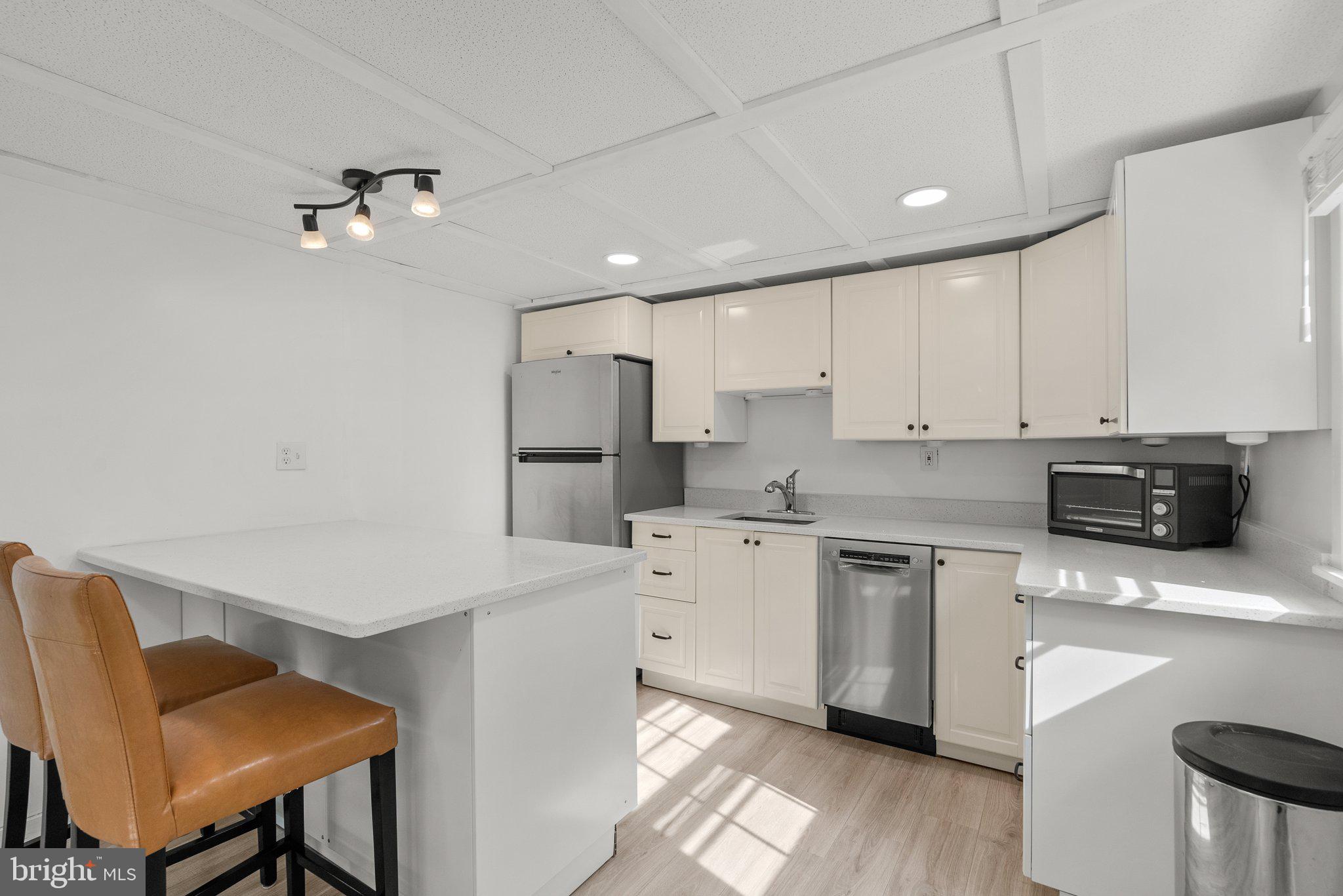 10406 Brookmoor Drive Silver Spring, MD 20901 - Photo 33 of 45 a kitchen with white cabinets stainless steel appliances and a dining table