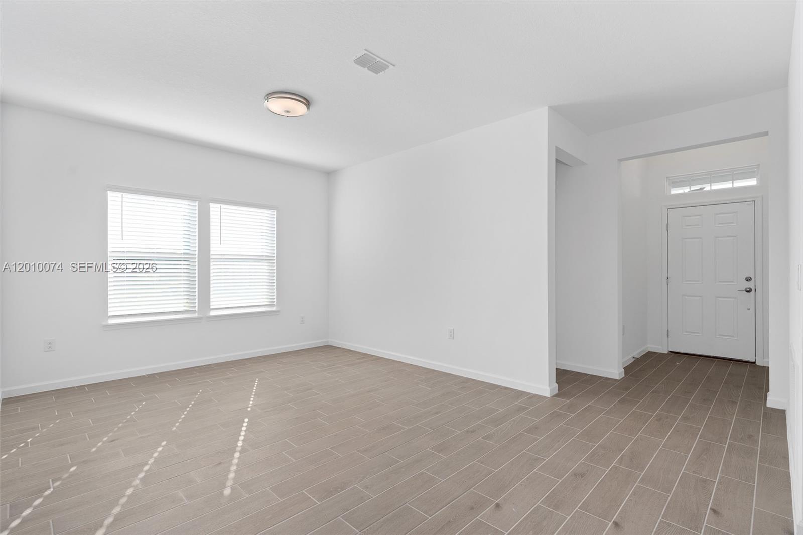 7789 Southwest 196th Terrace, Unit 1 Dunnellon, FL 34432 - Photo 11 of 36 a view of an empty room with wooden floor and a window