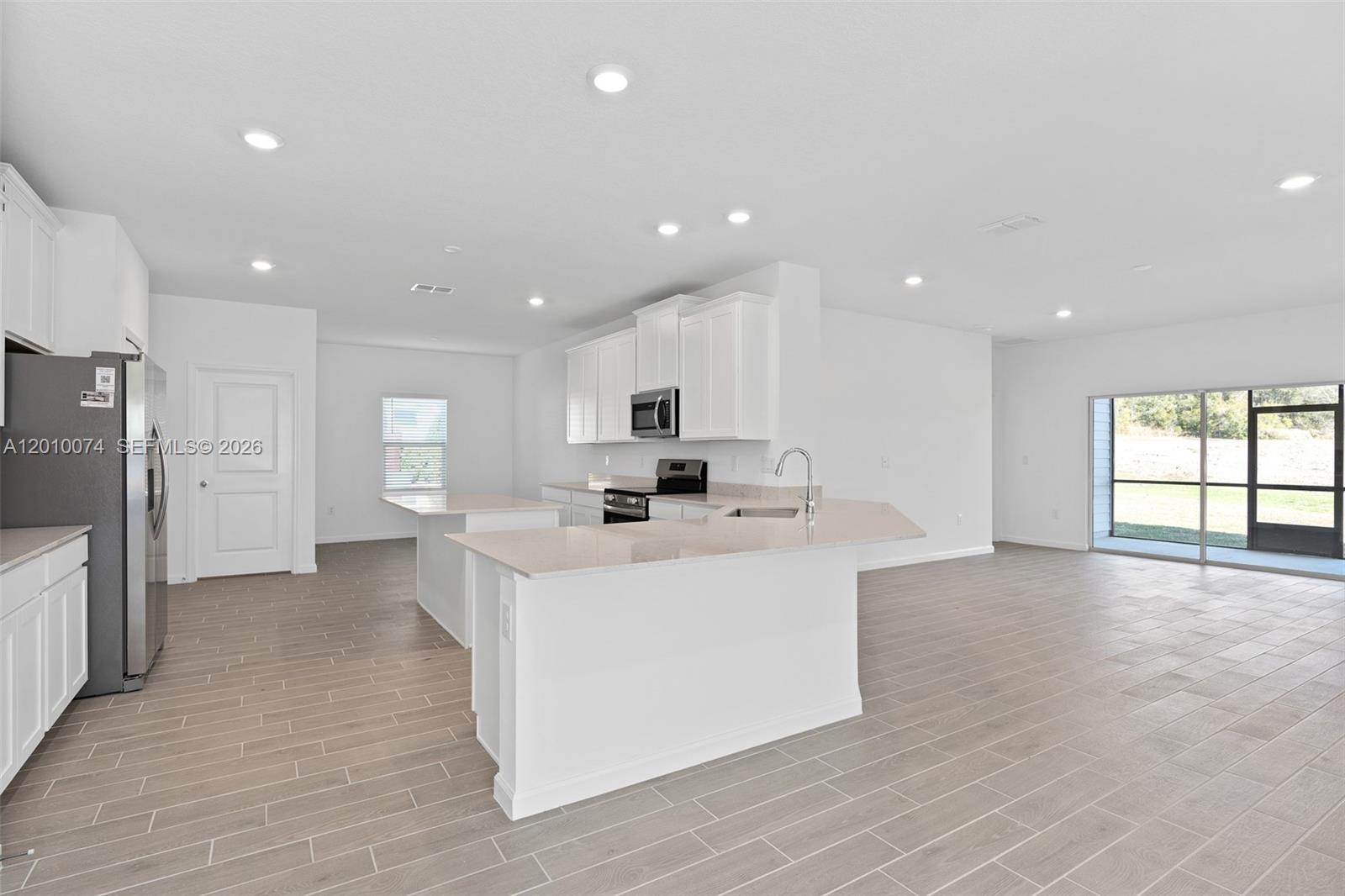 7789 Southwest 196th Terrace, Unit 1 Dunnellon, FL 34432 - Photo 12 of 36 a view of kitchen with center island stainless steel appliances wooden floor and window
