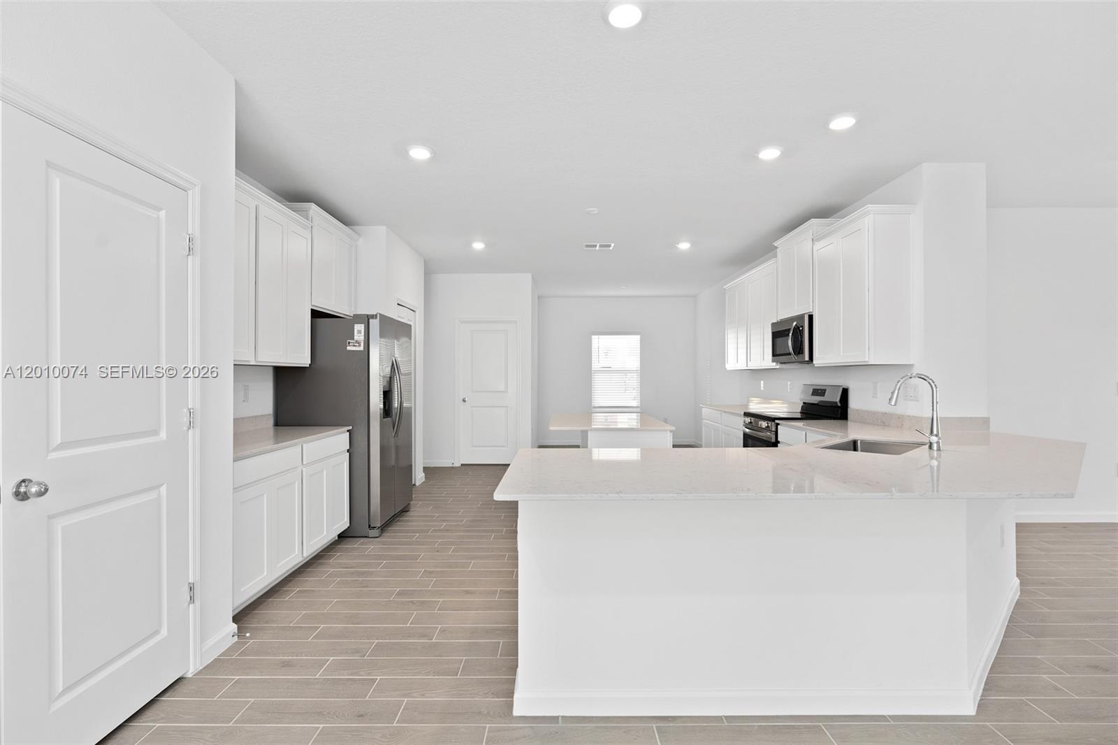 7789 Southwest 196th Terrace, Unit 1 Dunnellon, FL 34432 - Photo 14 of 36 a large white kitchen with cabinets and stainless steel appliances