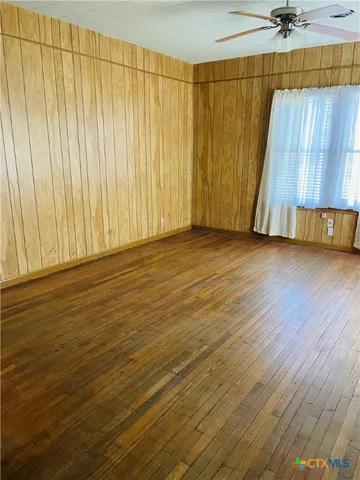 a view of a room with wooden floor and a table chair
