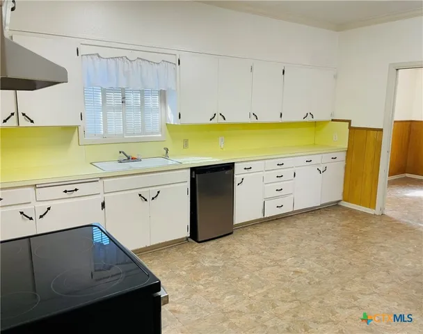 a kitchen with a sink a stove and cabinets