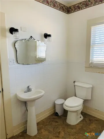 a white toilet sitting next to a white sink