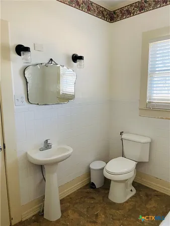a white toilet sitting next to a white sink