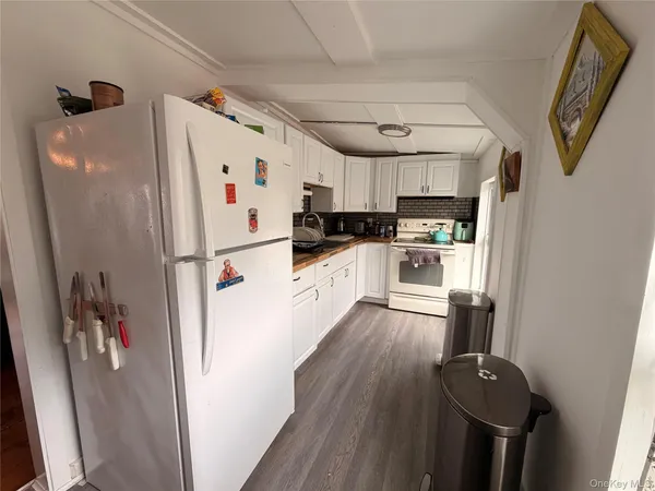 a kitchen with stainless steel appliances a refrigerator a stove a sink a chimney and wooden floor