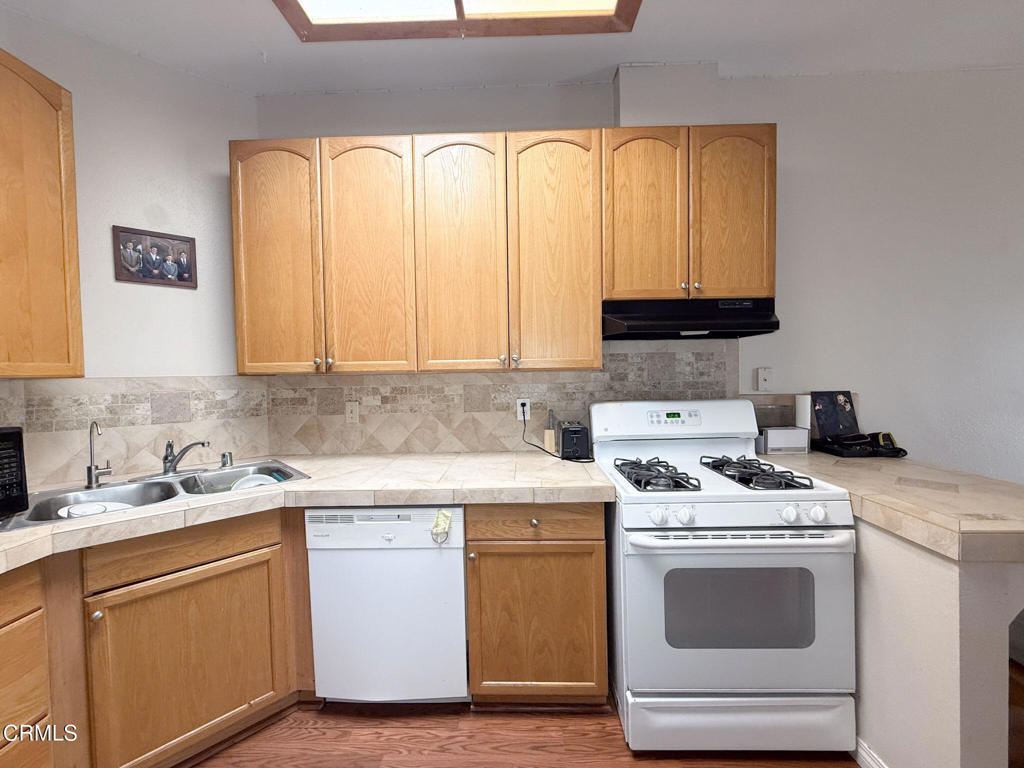 3000 Isle Way, Unit C Oxnard, CA 93035 - Photo 5 of 22 a view of cabinets a sink and a stove top oven sitting inside of a kitchen