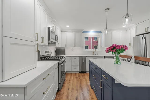 a kitchen with a sink a refrigerator and cabinets