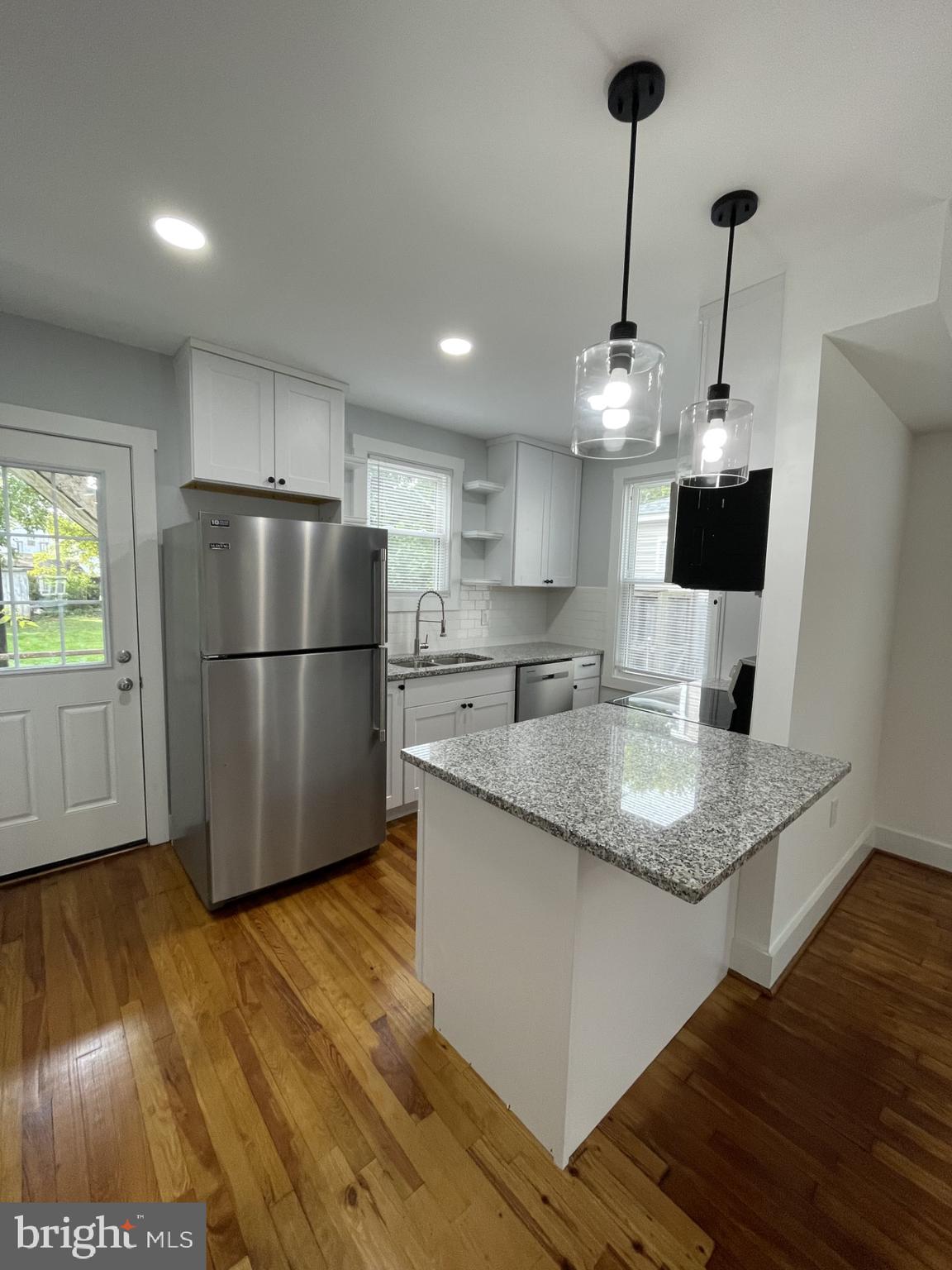 618 Wolfe Street, Unit A Fredericksburg, VA 22401 - Photo 4 of 13 a kitchen with stainless steel appliances granite countertop a refrigerator a sink dishwasher a stove and a wooden floor