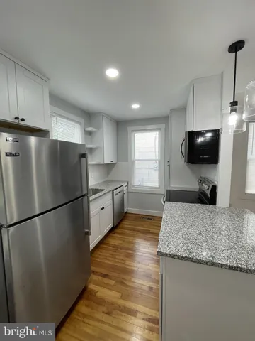 a kitchen with a refrigerator a sink and a stove top oven