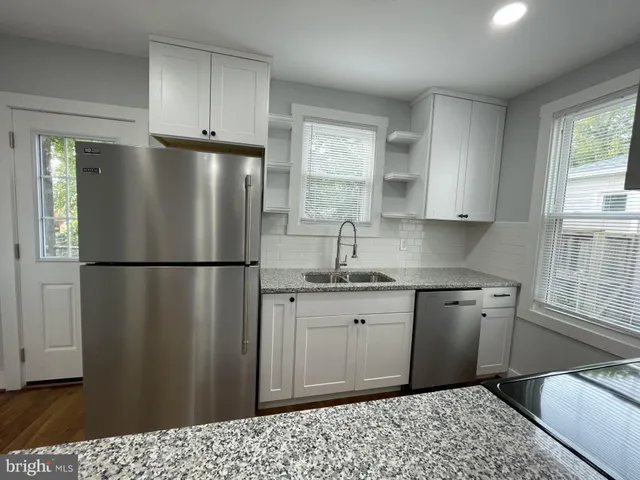 a kitchen with granite countertop a refrigerator and a sink