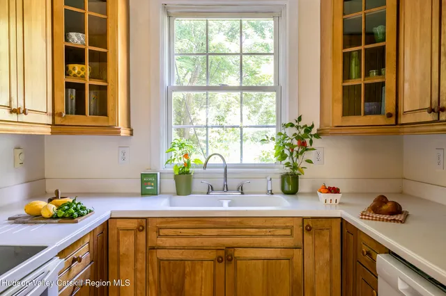a kitchen with stainless steel appliances white cabinets and wooden floor