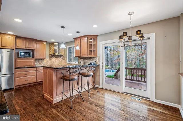 a kitchen with stainless steel appliances granite countertop a refrigerator and a stove top oven