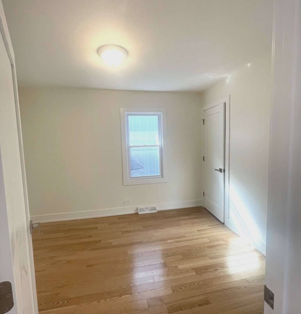 26073 West Grand Avenue Ingleside, IL 60041 - Photo 23 of 36 an empty room with wooden floor and windows