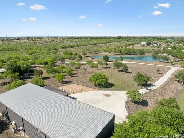an aerial view of residential houses with outdoor space and trees