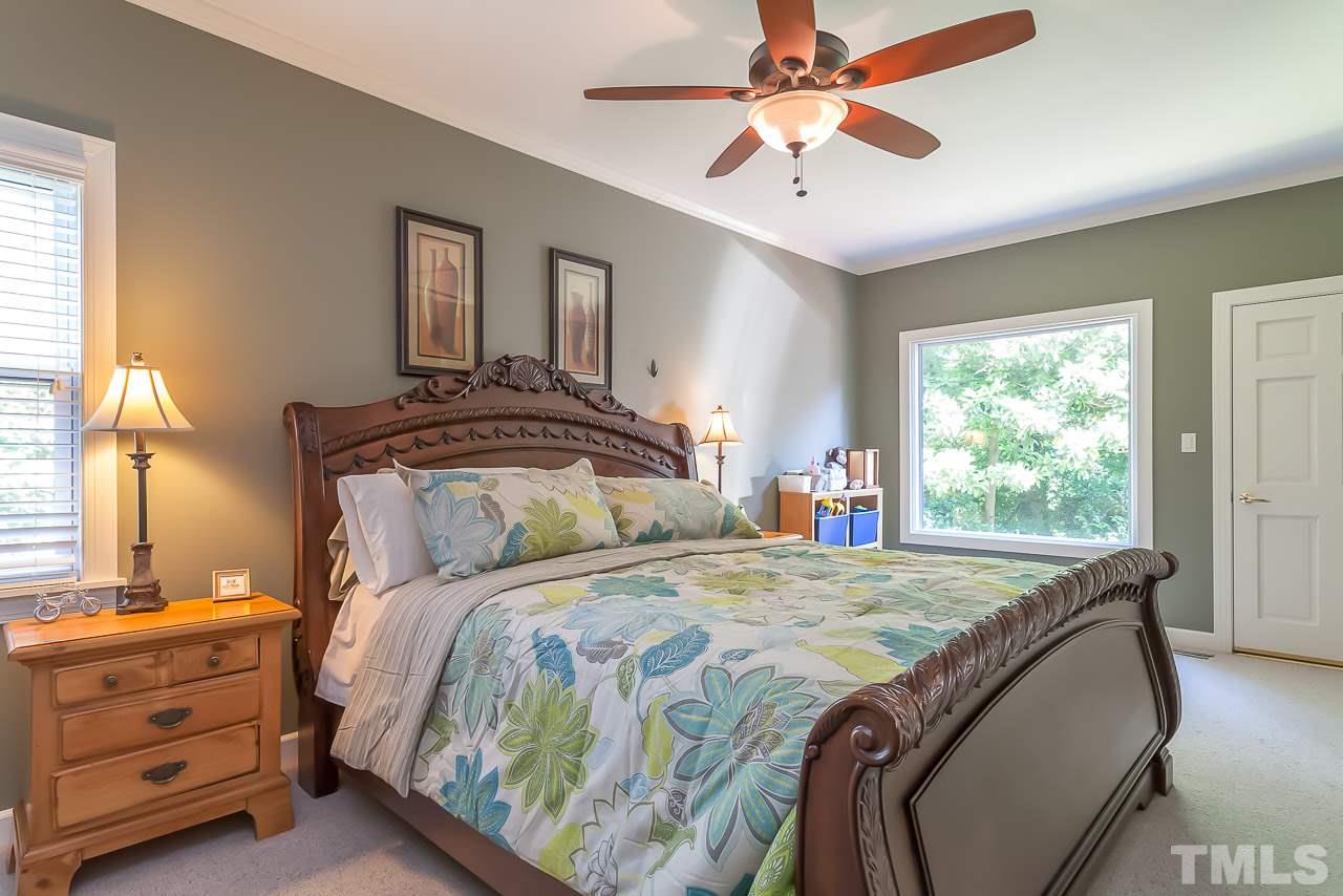 2518 Beechridge Road Raleigh, NC 27608 - Photo 8 of 25 a bedroom with a bed and a chandelier