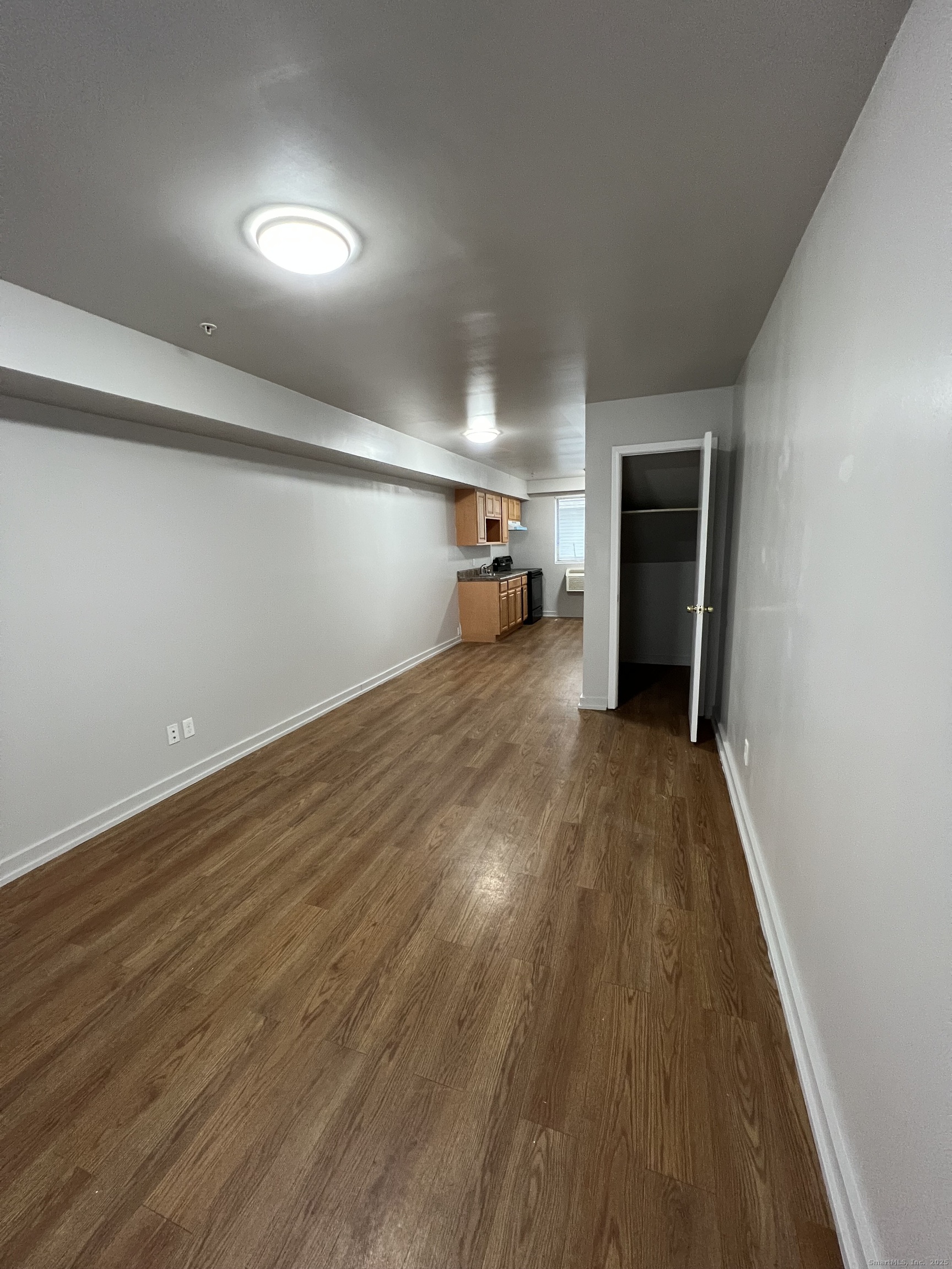 385 Putnam Avenue, Unit 38 Hamden, CT 06517 - Photo 3 of 15 wooden floor in an empty room with a window
