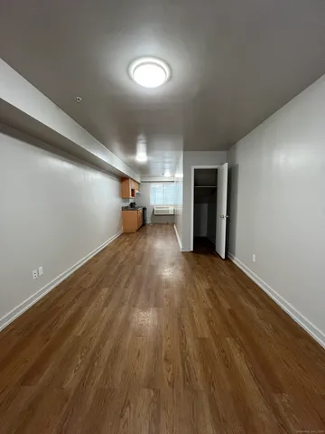 a view of a room with wooden floor and a window