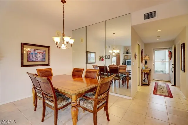 a view of a dining room and livingroom with furniture a chandelier and kitchen view