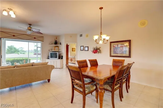 a dining room with furniture a chandelier and window