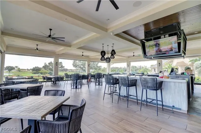 a dining room with wooden floor a chandelier fan a glass table and chairs