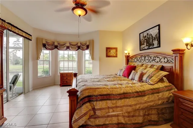 a bedroom with a bed a mirror and a large window