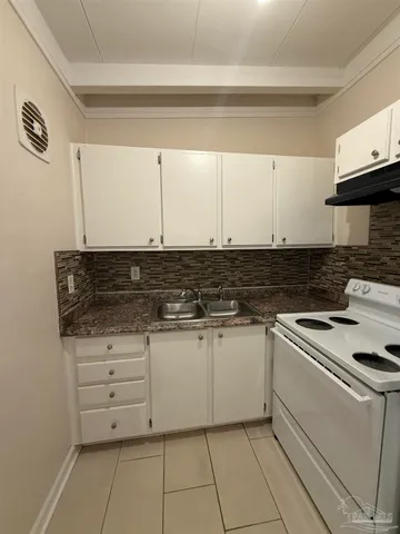 a kitchen with granite countertop white cabinets and white appliances
