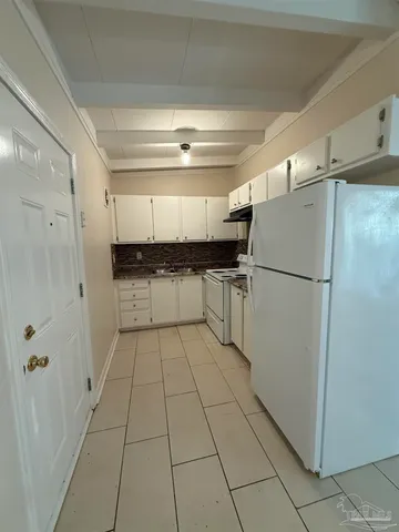 a kitchen with granite countertop a refrigerator and a sink