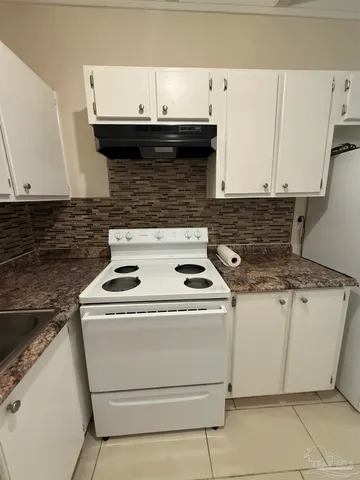 a stove top oven sitting inside of a kitchen