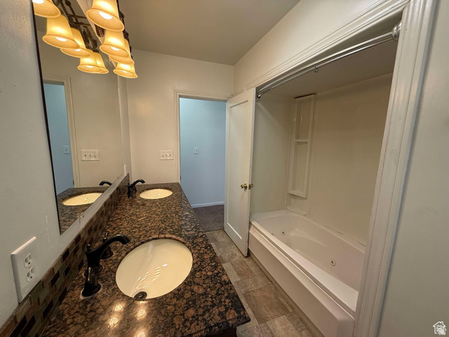 73 Garden Street Helper, UT 84526 - Photo 25 of 36 Full bath featuring double vanity, a jetted tub, suspended lighting, and dark stone finish floors