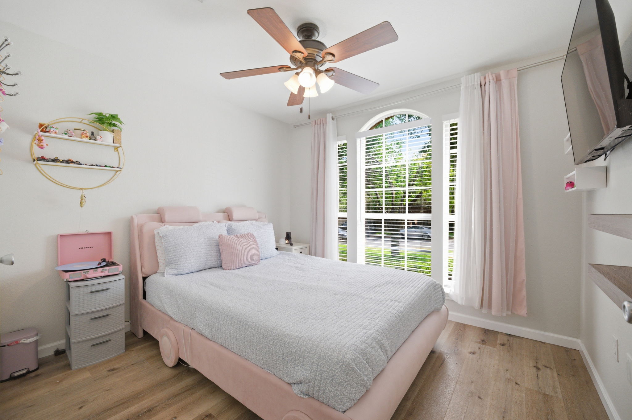 9024 Heiden Lane Austin, TX 78749 - Photo 12 of 28 Bright interior space featuring wood-finish flooring, a ceiling fan with integrated lighting, and a large arched window with blinds