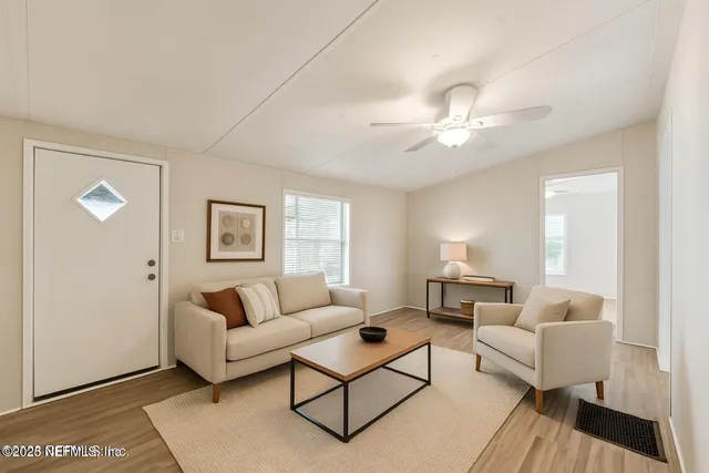 a living room with furniture a lamp on a table and a window