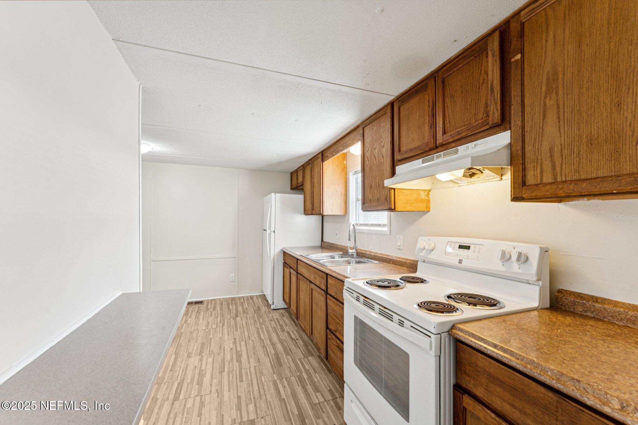 781 Hamilton Avenue St. Augustine, FL 32084 - Photo 15 of 39 a kitchen with a stove a sink and a refrigerator