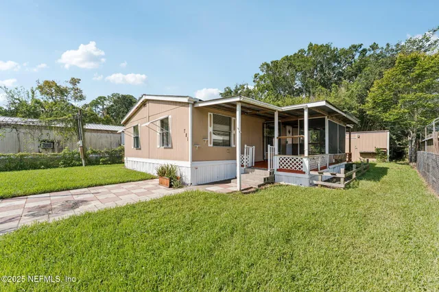 a view of a house with a yard and sitting area