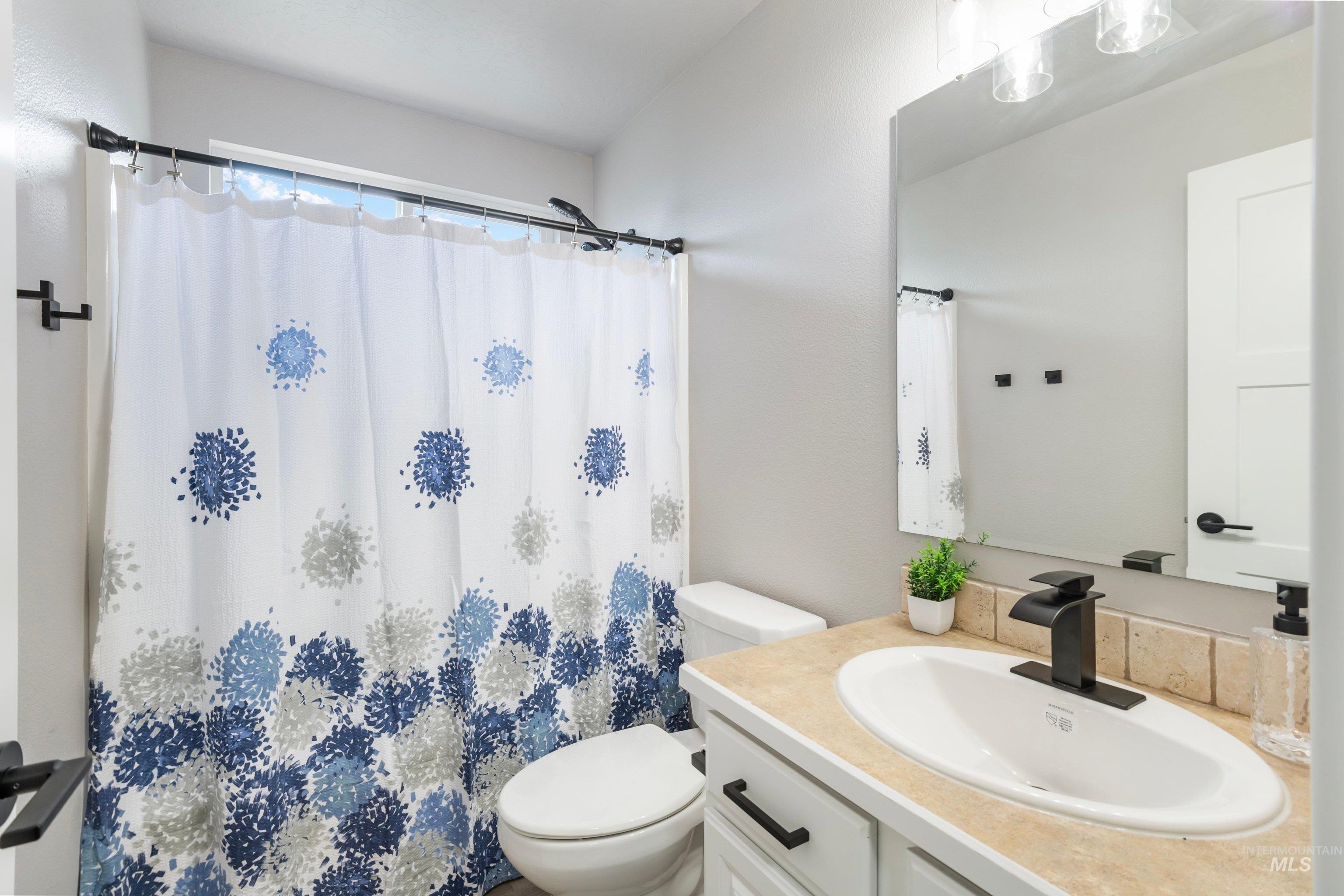 16759 Abram Avenue Caldwell, ID 83607 - Photo 19 of 33 Bathroom featuring a single vanity with an integrated sink, a rectangular mirror, and an overhead light fixture