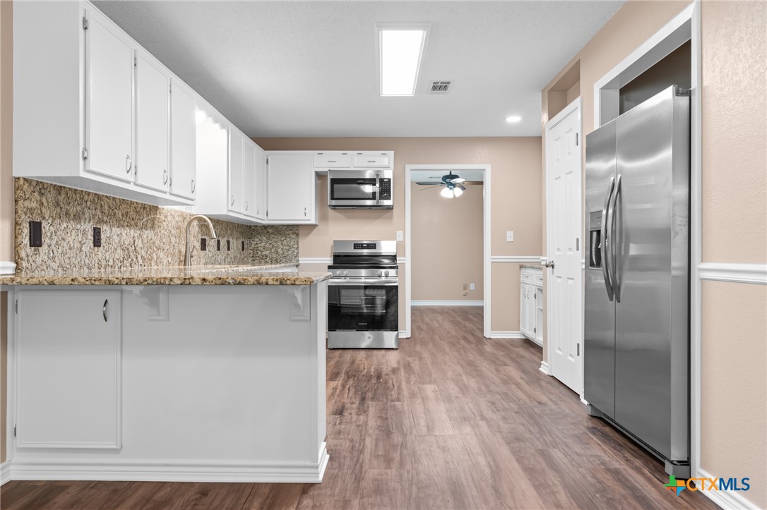607 South Nancy Ann Street Hamilton, TX 76531 - Photo 7 of 26 a kitchen with stainless steel appliances granite countertop a refrigerator a stove and a sink