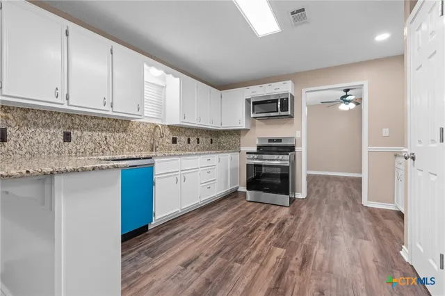 a kitchen with stainless steel appliances granite countertop a stove sink and cabinets