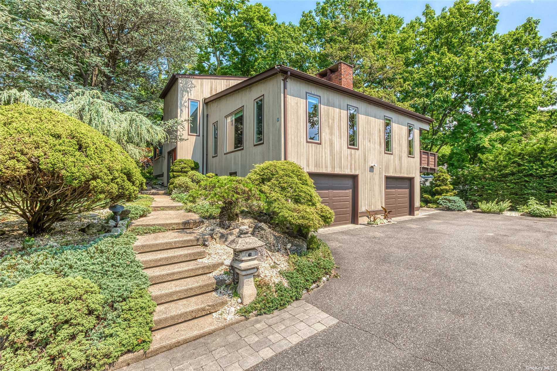 6 Ridgeway Road Port Washington, NY 11050 - Photo 1 of 1 a front view of a house with a yard and garage
