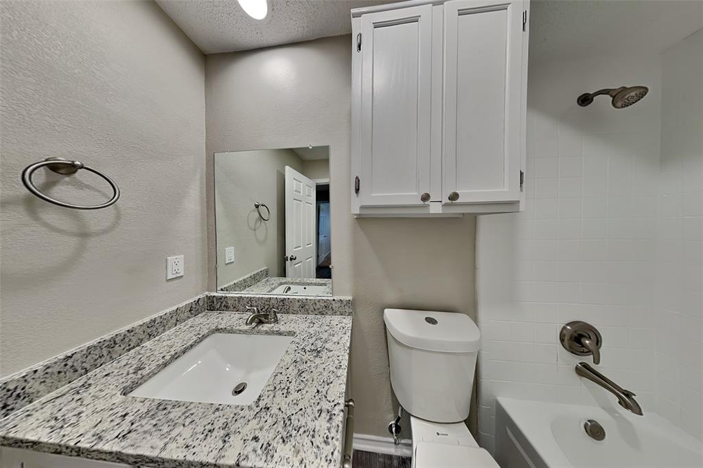 1602 Spring Street Allen, TX 75002 - Photo 17 of 20 a bathroom with a sink a toilet and a mirror