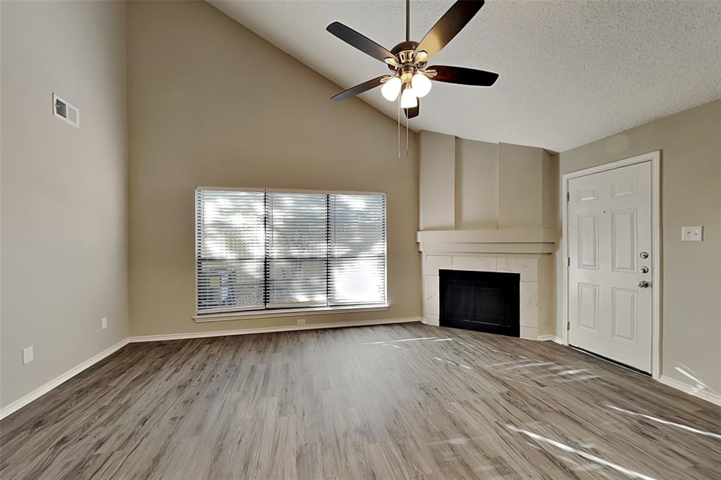 1602 Spring Street Allen, TX 75002 - Photo 2 of 20 an empty room with windows fireplace and wooden floor