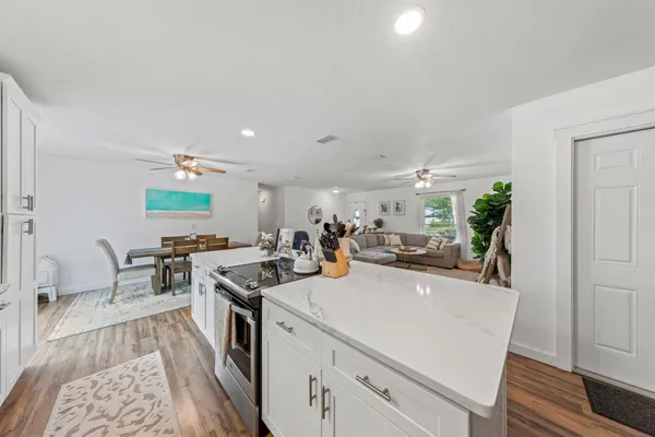 a view of a kitchen with kitchen island stainless steel appliances a sink a counter top space and a window