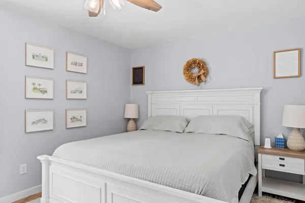 a bedroom with a bed and painting on the wall