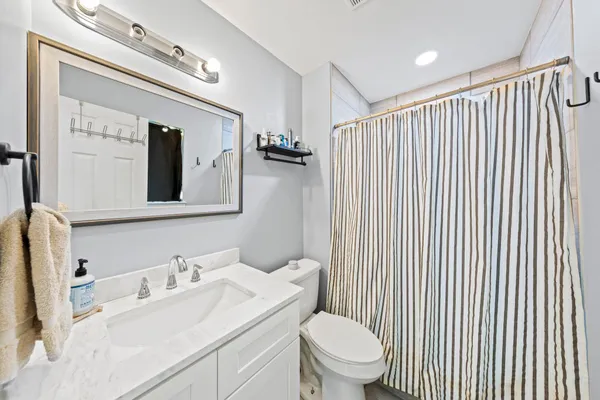 a bathroom with a toilet sink vanity and mirror
