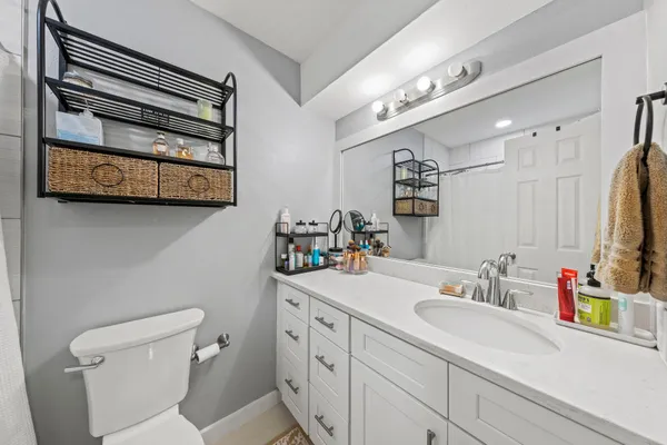 a bathroom with a sink a toilet and a mirror